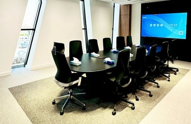 Modern meeting room with black mesh chairs and presentation screen
