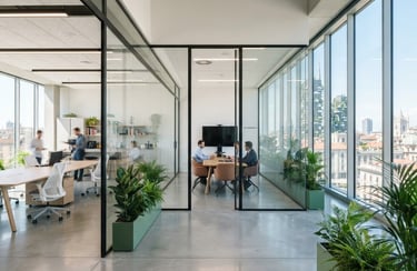 Wide-angle architectural photograph of a bright, modern Milanese office interior with clean glass partitions, natural light reflecting on polished concrete floors, minimalist green accents.