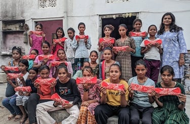 Schoolgirls holding up a Hanaru reusable sanitary napkin