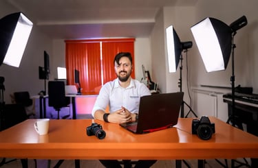 a man sitting at a table with a laptop computer