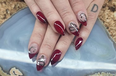 Red custom acrylic nail art with snakes and stiletto tips tips