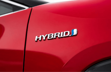Detalhe do emblema Hybrid em carro vermelho híbrido