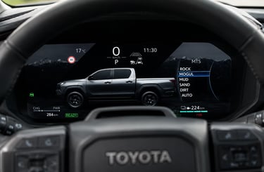 Painel digital da nova Hilux elétrica com modos de terreno e autonomia exibida