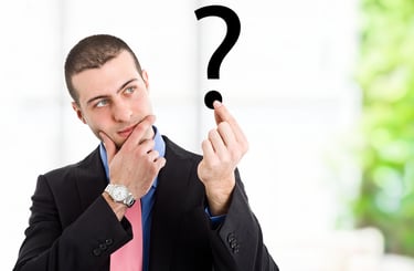 a man in a suit and tie is holding a question mark