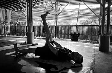 A man practices a yoga pose at Bamboo Cottage, Langkawi