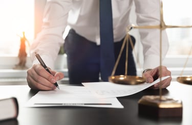 Person Writing in Front of Scales of Justice