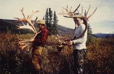 Alaska caribou hunting guide and client with a trophy harvest in the field.