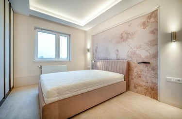 Sypialnia z łóżkiem i materacem, tapicerowany zagłówek, ściana z tapetą w ptaki, okno i oświetlenie 