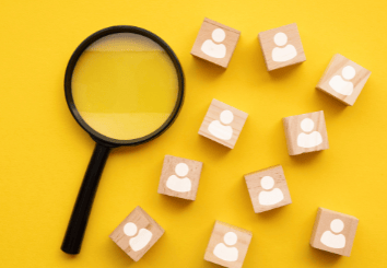 bir büyüteç ve üzerlerinde insan figürü olan tahta bloklar