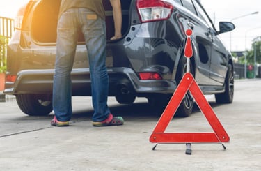 a man standing in front of a broke down car