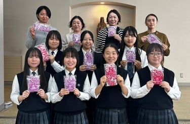 Eleven teachers and school girls holding up Hanaru's sanitary napkins.