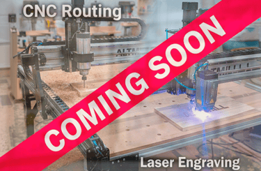 Industrial CNC routing and laser engraving machines in a workshop with a coming soon banner.