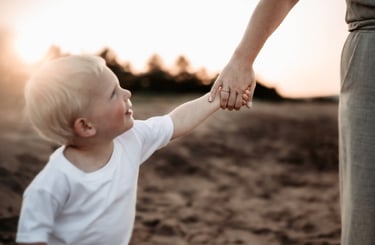 Toddler holding mother’s hand during sunset, Park Point Duluth MN