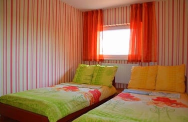 two twin beds in a room with striped walls