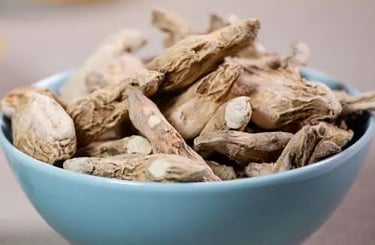 A blue ceramic bowl filled with dried ginger root pieces for cooking and herbal tea.