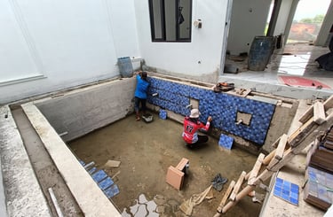 proses pembuatan kolam renang dan pemasangan keramik roman motif mozaik.