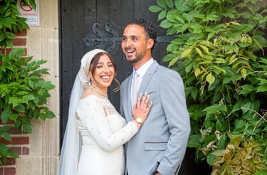 bride and groom in front of stately home being candid laughing and smiling 