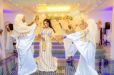 Somalian bride dancing in centre, bridesmaids in a circle around bride all happy and having a good time
