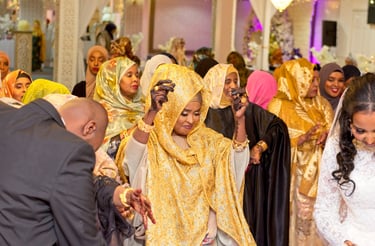 candid photo of mother Somalian bride dancing with bride and groom, all happy, wearing vibrant colours of clothing  