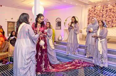 Somalian bride in centre dancing with bridesmaids, all happy and in traditional dresses 