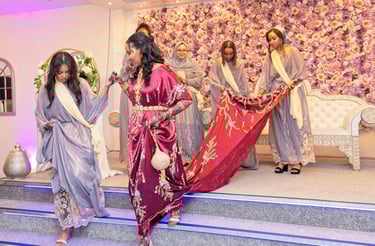 Somalian bridesmaids helping bride off stage, all in traditional vibrant colours dresses 