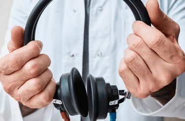 Um homem segurando um fone de exames audiológicos