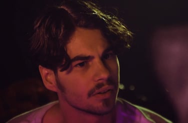 a man with a beard and a pink shirt