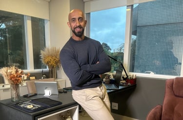 a man standing in a room with a desk and a chair