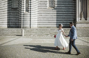 a bride and groom walking down the stairs of a church