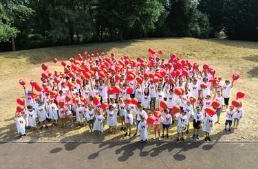 Photo de groupe festive avec ballons rouges pour la journée du personnel de l’entreprise Weigerding.