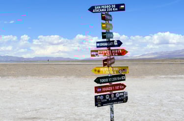 South American sign post with city names in Spanish represents the benefit of Spanish for travel