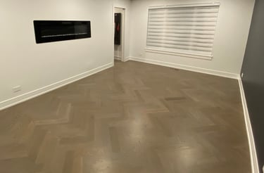 Custom herringbone hardwood flooring installation with modern fireplace in a Chicago North Shore home