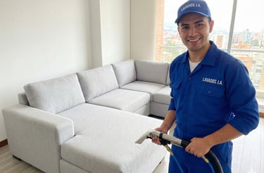 Técnico lavando sofá en Ibagué con máquina profesional