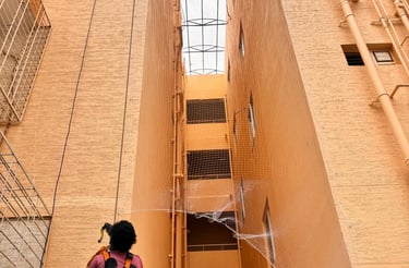 A technician installing anti-pigeon safety nets on a Pune balcony.