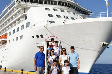 A warm, inviting photo of a family happily chatting with a travel agent over cruise brochures.