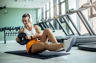 a lady wearing white headphones and doing an abs execise with a weighted plate