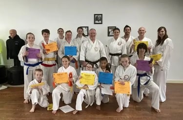 Students earning new belts pose on promotion day