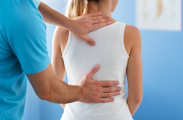 Physiotherapist guiding posture correction exercise for neck and spine.