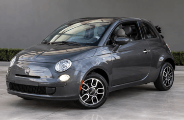 Fiat 500 cinza em showroom externo moderno com fundo neutro e visual premium.