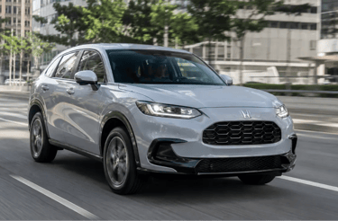 Honda ZR-V Touring prata em movimento em avenida urbana