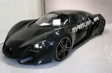 Marussia B2 preto em exposição com design futurista e visual de supercarro