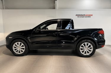Porsche Cayenne transformado em picape customizada em showroom automotivo.