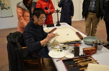 an artist sitting painting at a workshop