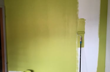 a room with a green wall and a paint roller
