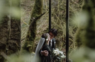 a bride and groom kissing on a bridge