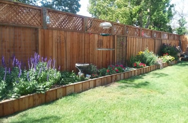 a new fenced in garden with a bird feeder