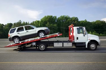 <img src="junk-car-tow-truck-loading.jpg" alt="Tow truck loading a silver SUV for junk car removal o