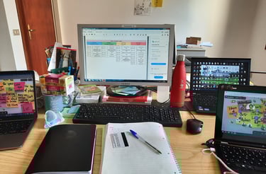Scrivania con laptop, appunti, libri e oggetti di cancelleria in ufficio