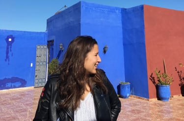 Guide touristique souriante, devant l’architecture marocaine aux couleurs éclatantes.