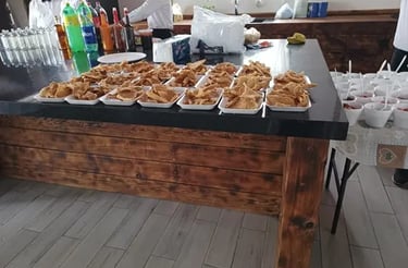 Barra de botanas con chicharrón preparado y bebidas en servicio de catering para evento en Querétaro.